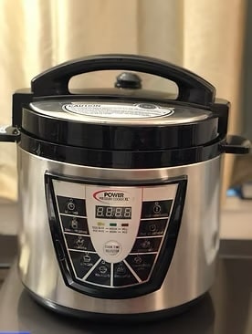 Stainless steel Power Pressure Cooker XL with a black digital control panel, locked lid, and steam release valve.