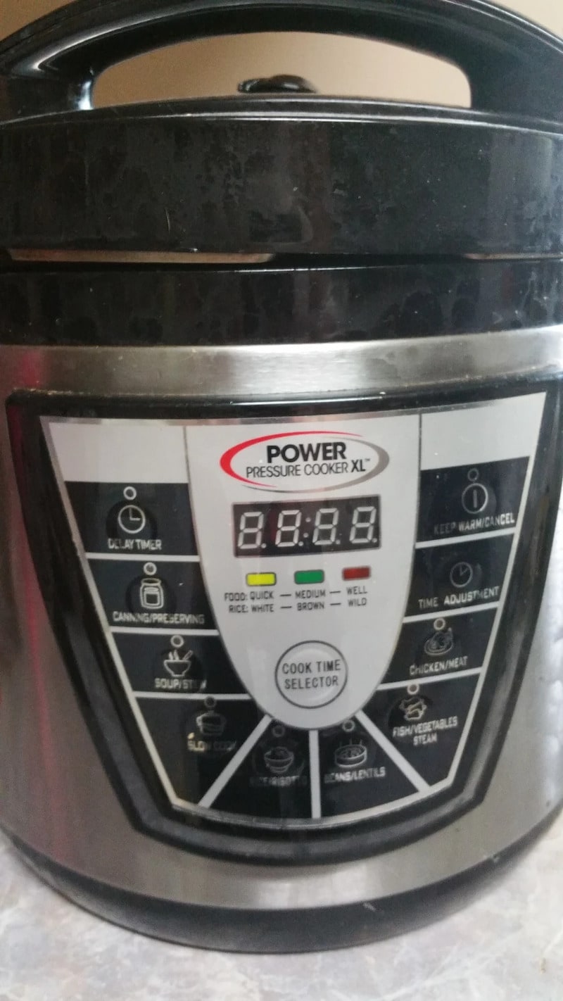 Close-up of the control panel on a Power Pressure Cooker XL, showing the digital display and touch buttons for various cooking functions like canning, soup, and slow cook.