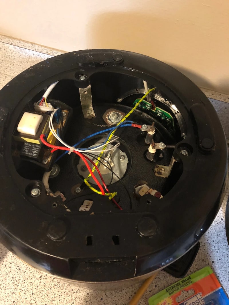 The internal wiring and electrical components of a disassembled Power Pressure Cooker XL, showing the heating element connections, circuit board, and colored wires.